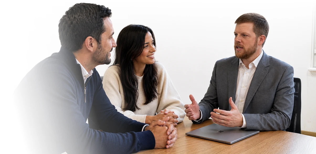 A couple meets with an advisor to discuss their family coaching plan.