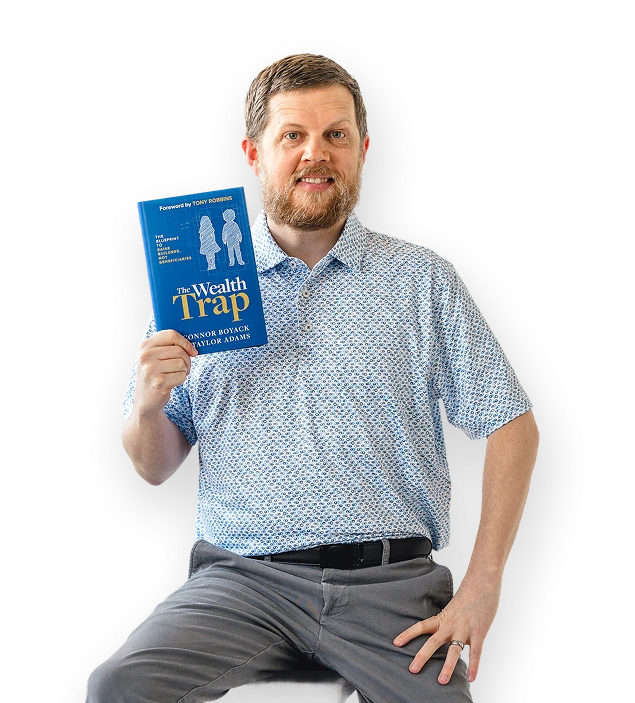 Connor Boyack sitting and holding a copy of The Wealth Trap.