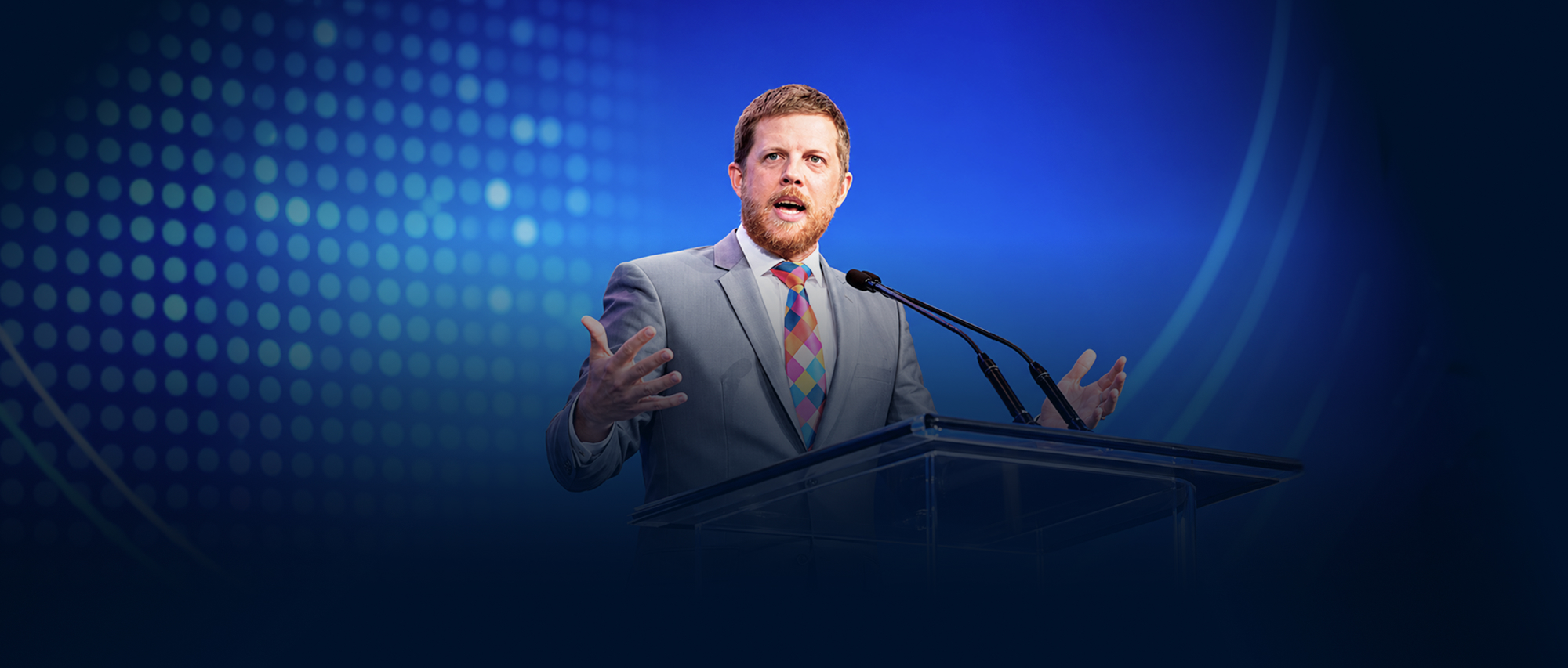 Connor Boyack speaks at a podium at a conference.